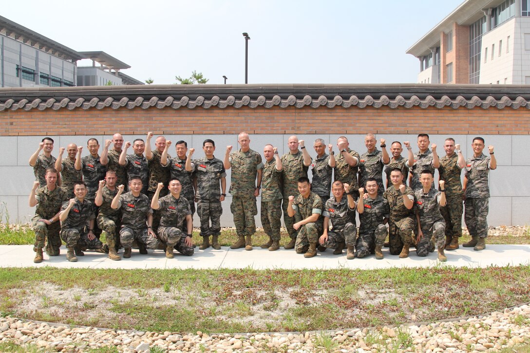 USAG CAMP HUMPHREYS, Korea – Lt. Gen. Jun, Jin Goo (center-left), commandant of the Republic of Korea Marine Corps, and Maj. Gen. Patrick J. Hermesmann (center-right), commander of U.S. Marine Corps Forces Korea, along with principal staff from both services raise a fist together here, July 24. Jun visited MARFORK to talk to Marines and strengthen the alliance between the ROK Marine Corps and U.S. Marine Corps. (U.S. Marine Corps photo by Sgt. Nathaniel Hanscom/Released)