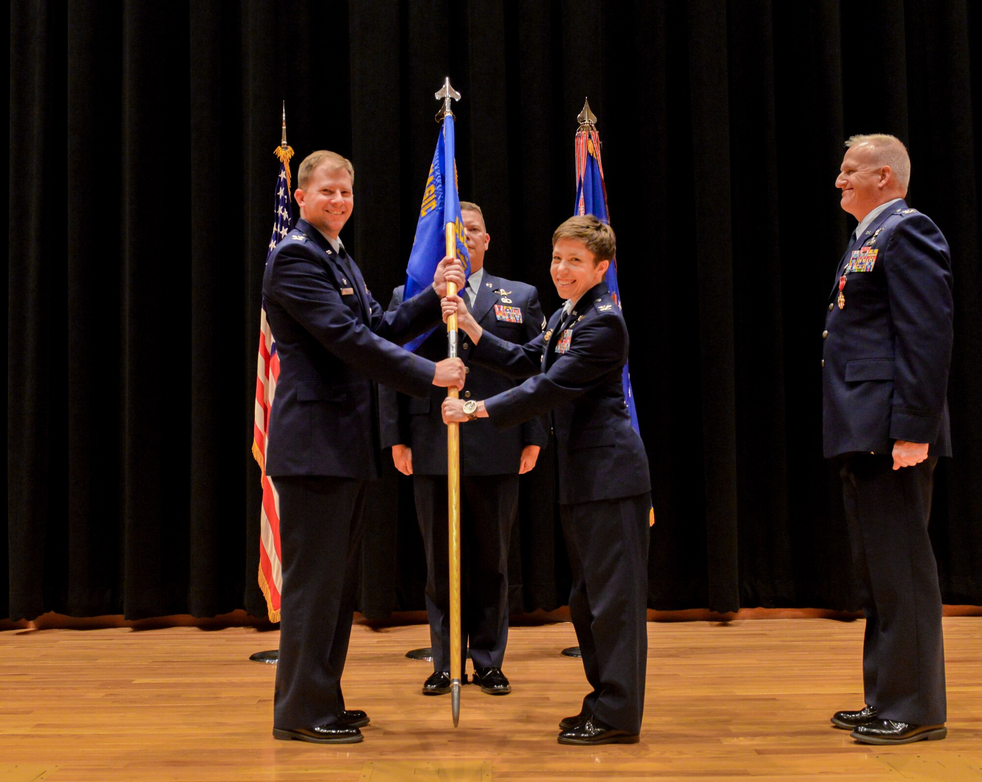 Col. Katharine Barber (middle), accepts command of the National Air and Space Intelligence Center’s Space, Missiles and Forces Intelligence Group from Col. Parker Wright, NASIC commander, July 6. SM is responsible to deliver integrated, predictive intelligence on space, ballistic missile, regional and future threat capabilities to enable U.S. decision-making advantage in the air, space and cyber domains. (U.S. Air Force photo/ Senior Airman Samuel Earick)