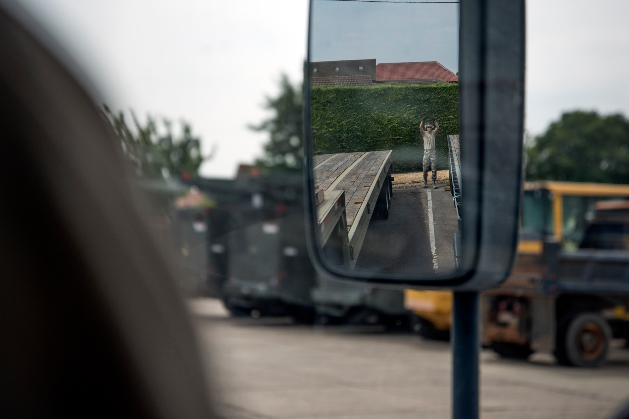 U.S. Air Force Airman 1st Class Dennis Fite, 100th Logistics Readiness Squadron ground transportation operator, spots a vehicle for parking on RAF Mildenhall, England, July 20, 2018. Ground transportation Airmen deliver heavy equipment to units on and off base, and they also provide transportation to official appointments and ensure Airmen receive their mail by doing daily mail runs to and from RAF Alconbury. (U.S. Air Force photo by Senior Airman Christine Groening)