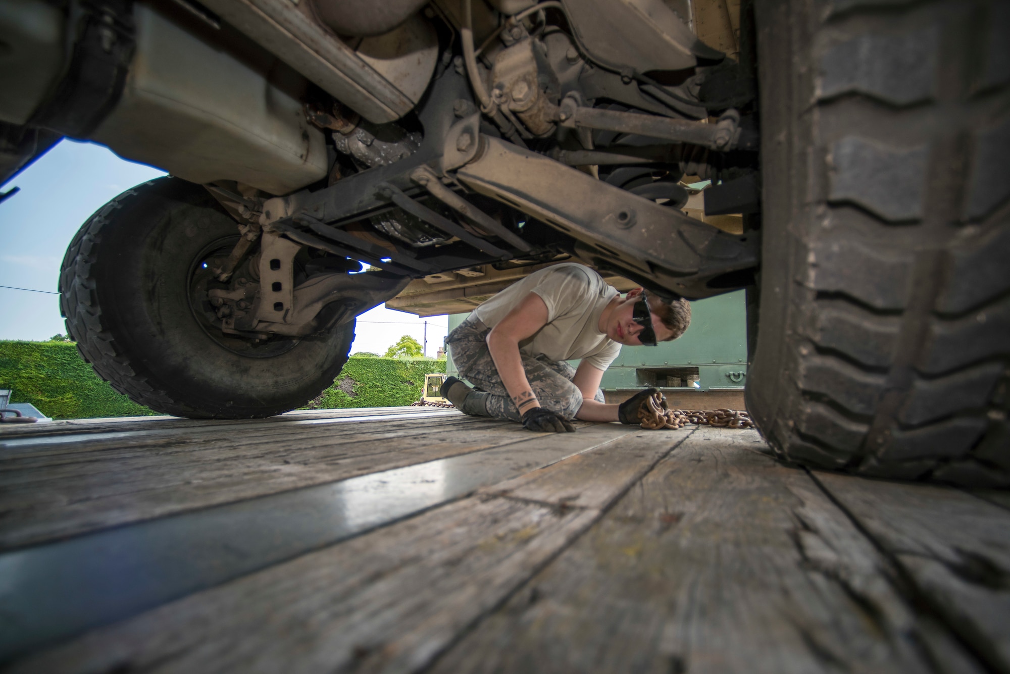 U.S. Air Force Airman 1st Class Dennis Fite, 100th Logistics Readiness Squadron ground transportation operator, ensures a HUMVEE is properly loaded on a trailer at RAF Mildenhall, England, July 20, 2018. Technical training for ground transportation Airmen is just under a month long, where they learn how to tie down heavy equipment and how to drive a variety of vehicles. (U.S. Air Force photo by Senior Airman Christine Groening)