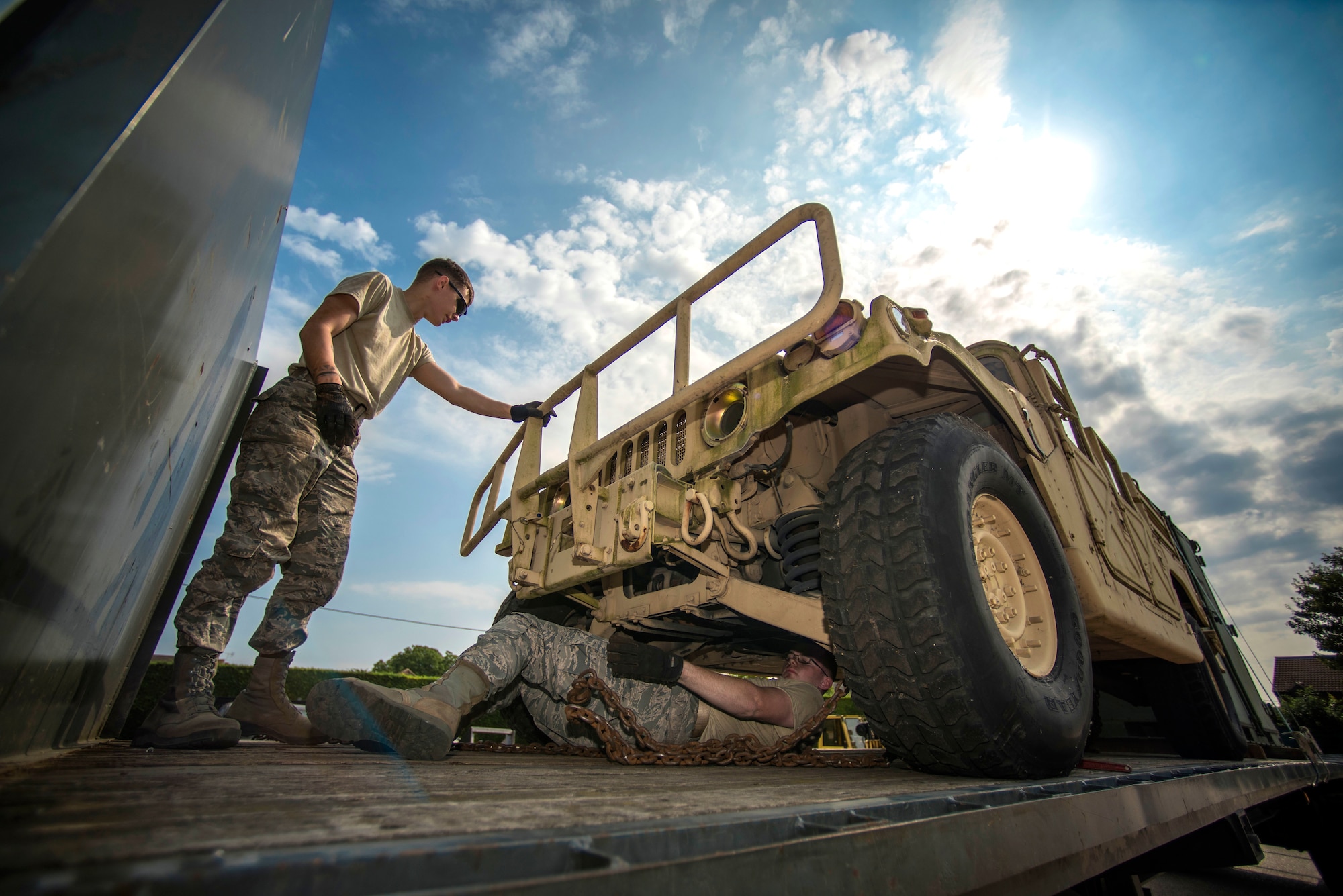U.S. Air Force Airman 1st Class Dennis Fite, left, and Airman 1st Class Brinkley Owens, both 100th Logistics Readiness Squadron ground transportation operators, conduct vehicle tie down procedures on RAF Mildenhall, England July 20, 2018. Ground transportation Airmen deliver heavy equipment to units on and off base, and they also provide transportation to official appointments and ensure Airmen receive their mail by doing daily mail runs to and from RAF Alconbury. (U.S. Air Force photo by Senior Airman Christine Groening)