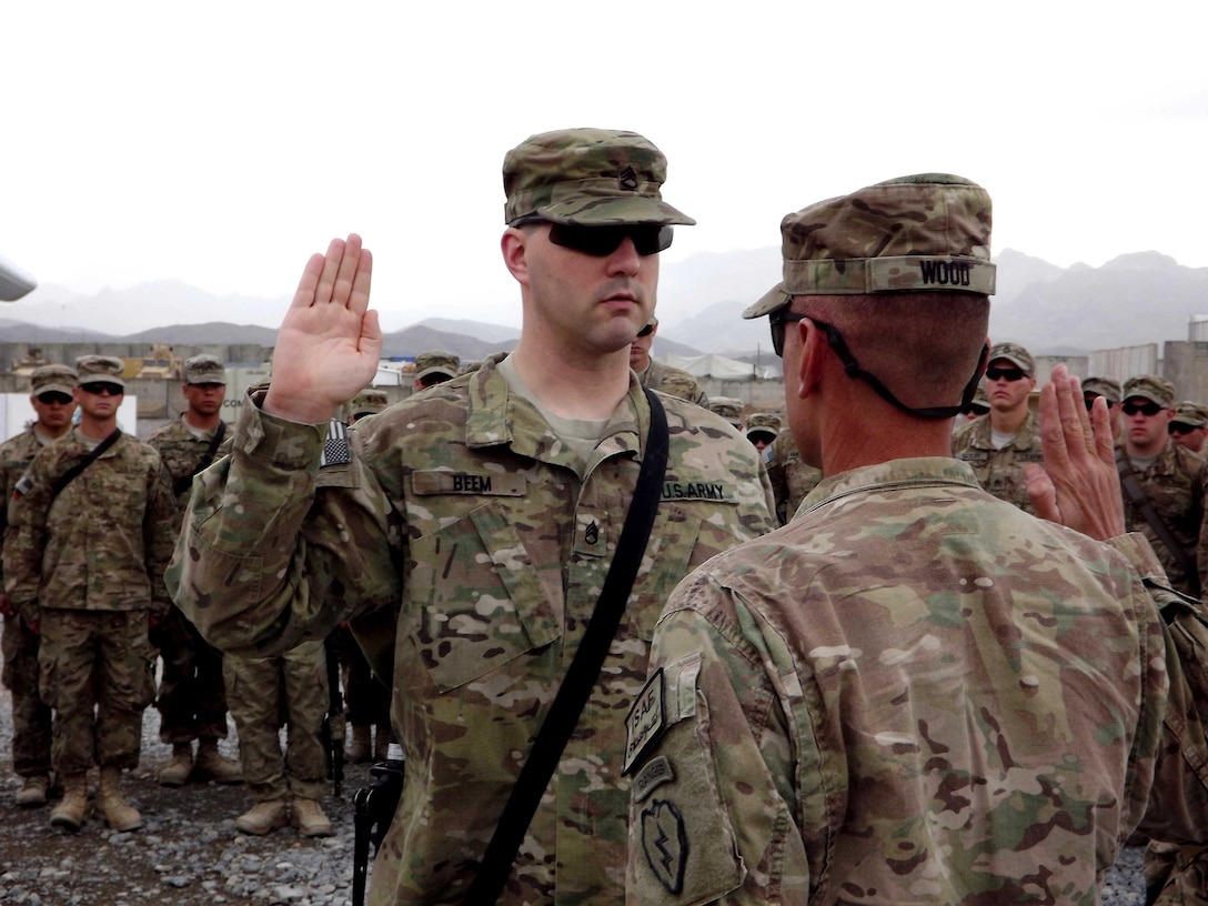 Soldier raises his hand at re-enlistmnent ceremony.