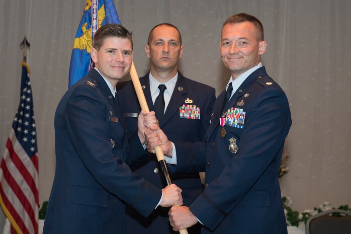 Lt. Col. Michael Speck, right, 628th Security Forces Squadron incoming commander, assumes command and accepts the squadron’s guidon from Col. Rockie Wilson, left, 628th Mission Support Group commander, during a change of command ceremony here at the Red Bank Club, July 23, 2018.