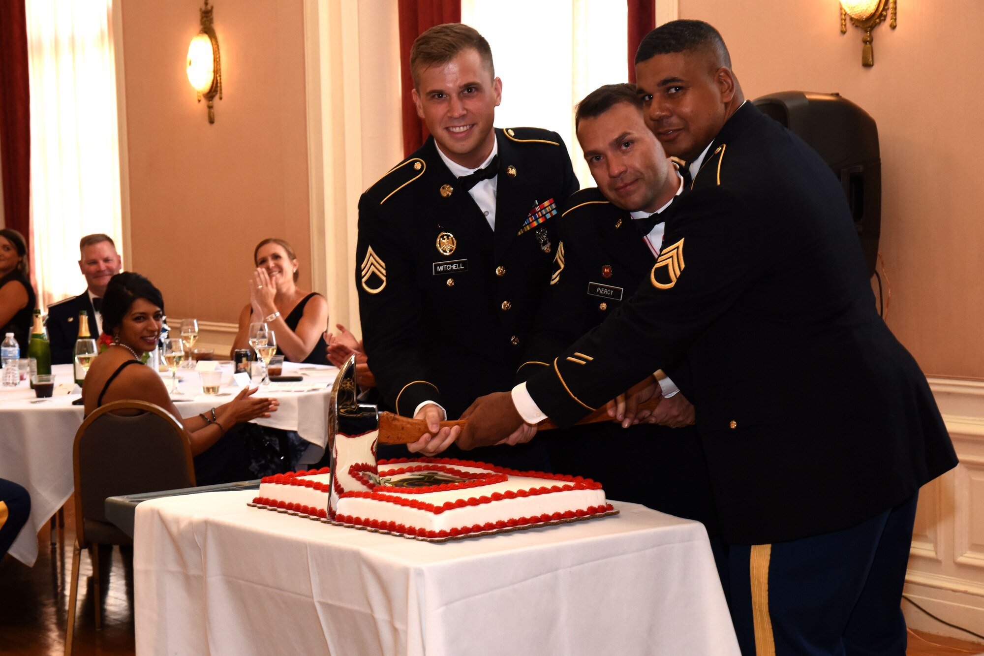 U.S. Army Staff Sgt. William Mitchell, Master Sgt. Jason Piercy and Staff Sgt. Benjamin Johnson, members of the 169th Engineer Battalion Firefighter Detachment, cut the battalion’s cake during the 344th Military Intelligence Battalion Centennial Celebration in honor of 100 years of intelligence and cryptology at the Cactus Hotel, San Angelo, July 20, 2018. The cake is traditionally cut by the youngest individual in the BN, the oldest member in the BN and the highest ranking. (U.S. Air Force photo by Airman 1st Class Seraiah Hines/Released)