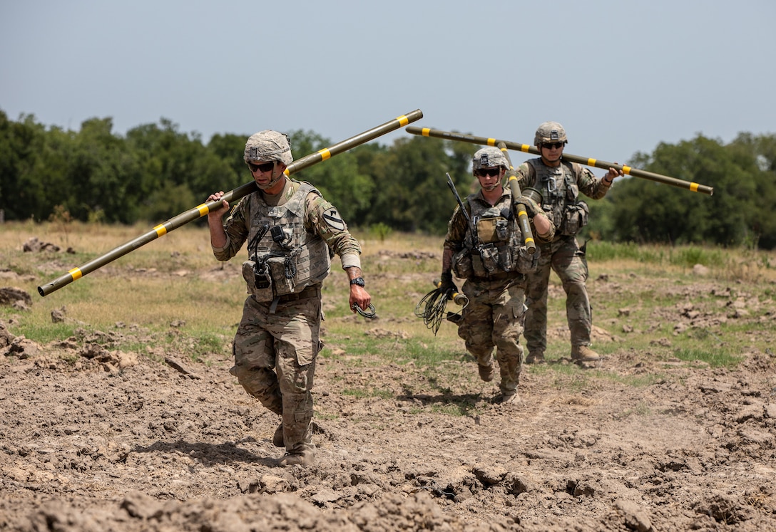 Combat engineers carry explosives during obstacle-breaching training.