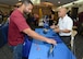 Izzy Avila, Penn State University outreach director (right), discusses his university's programs with a member of Team Edwards at the annual Education Fair held at Club Muroc July 24. (U.S. Air Force photo by Kenji Thuloweit)