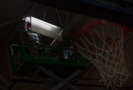 Senior Airman Joshua Okyere, 628th Civil Engineer Squadron electrical systems journeyman, upgrades lights July 25, 2018, at Joint Base Charleston’s fitness center. Okyere and a team of civil engineers replaced the fitness center basketball court’s fluorescent bulbs and ballasts with longer lasting LED bulbs. The 628th CES project leads expect the upgrade to reduce energy consumption 60 percent and required maintenance by 50 percent.