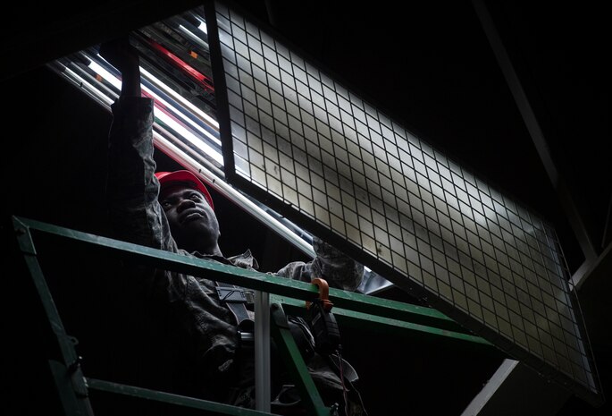 Senior Airman Joshua Okyere, 628th Civil Engineer Squadron electrical systems journeyman, upgrades lights July 25, 2018, at Joint Base Charleston’s fitness center. Okyere and a team of civil engineers replaced the fitness center basketball court’s fluorescent bulbs and ballasts with longer lasting LED bulbs. The 628th CES project leads expect the upgrade to reduce energy consumption 60 percent and required maintenance by 50 percent.