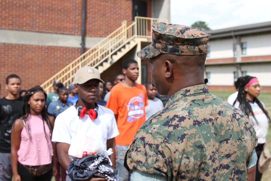 U.S. Marine Corps 1stSgt. James Williams welcomes dozens of Navy and Marine Corps Junior Reserve Officers Training Corps cadets upon arrival at Marine Corps Logistics Base Albany. More than 40 cadets spent an intense five days at MCLB Albany for its first-ever summer camp. Each cadet experienced a week-long taste of basic leadership training. (U.S. Marine Corps photo by Re-Essa Buckels)