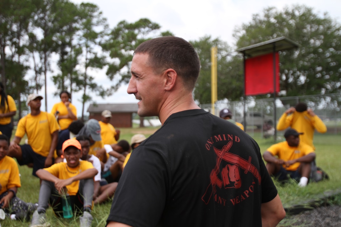 U. S. Marine Corps SSgt. James Ahearn shares information on proper techniques of the obstacle course with dozens of Navy and Marine Corps Junior Reserve Officers Training Corps cadets. More than 40 cadets spent an intense five days at Marine Corps Logistics Base Albany for its first-ever summer camp. Each cadet experienced a week-long taste of basic leadership training. (U.S. Marine Corps photo by Re-Essa Buckels)