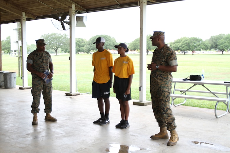 Marine Corps Logistics Base Albany Commanding Officer Colonel Alphonso Trimble (right) and Sergeant Major Johnny Higdon (left) recognizes the top two cadets who had the fastest times during the combat fitness tests. More than 40 cadets spent an intense five days at Marine Corps Logistics Base Albany for its first-ever summer camp. Each cadet experienced a week-long taste of basic leadership training. (U.S. Marine Corps photo by Re-Essa Buckels)