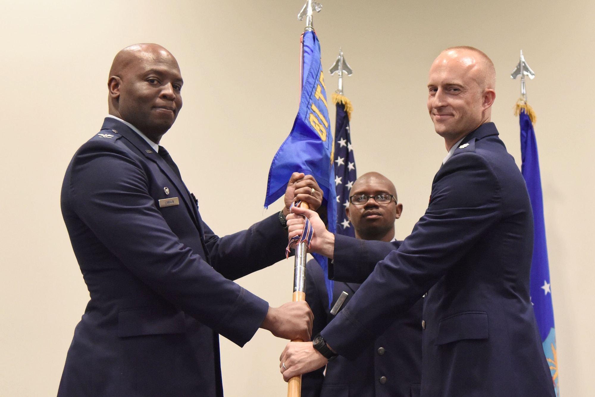 U.S. Air Force Col. Leo Lawson, Jr., 81st Training Group commander, passes the 333rd Training Squadron guidon to Lt. Col. Andrew Miller, 333rd TRS commander, during the 333rd TRS change of command ceremony in the Roberts Consolidated Aircraft Maintenance Facility at Keesler Air Force Base, Mississippi, July 24, 2018. The passing of the guidon is a ceremonial symbol of exchanging command from one commander to another. (U.S. Air Force photo by Kemberly Groue)