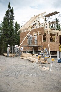 Members of the 149th Civil Engineer Squadron work to build a cabin.
