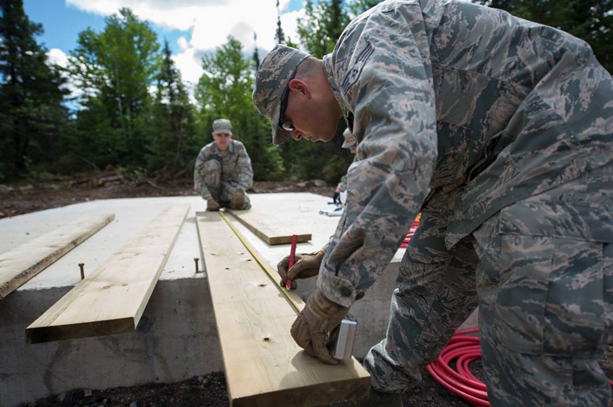 Members of the 149th Civil Engineer Squadron work to build a cabin.