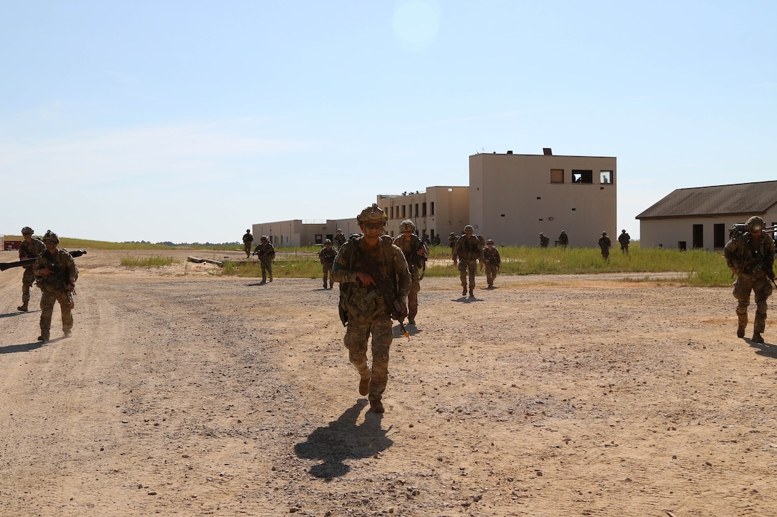 Soldiers maneuver in a wedge formation to their follow-on objective.