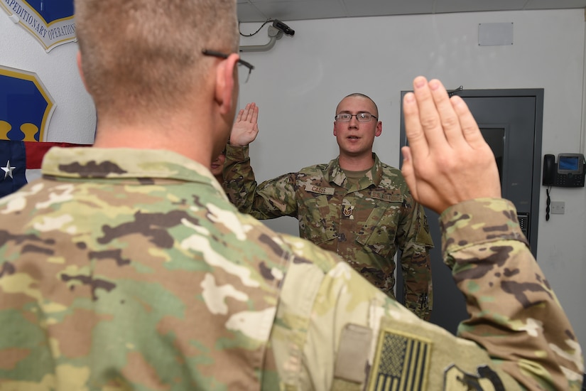 An Airman reads the oath of enlistment to his brother