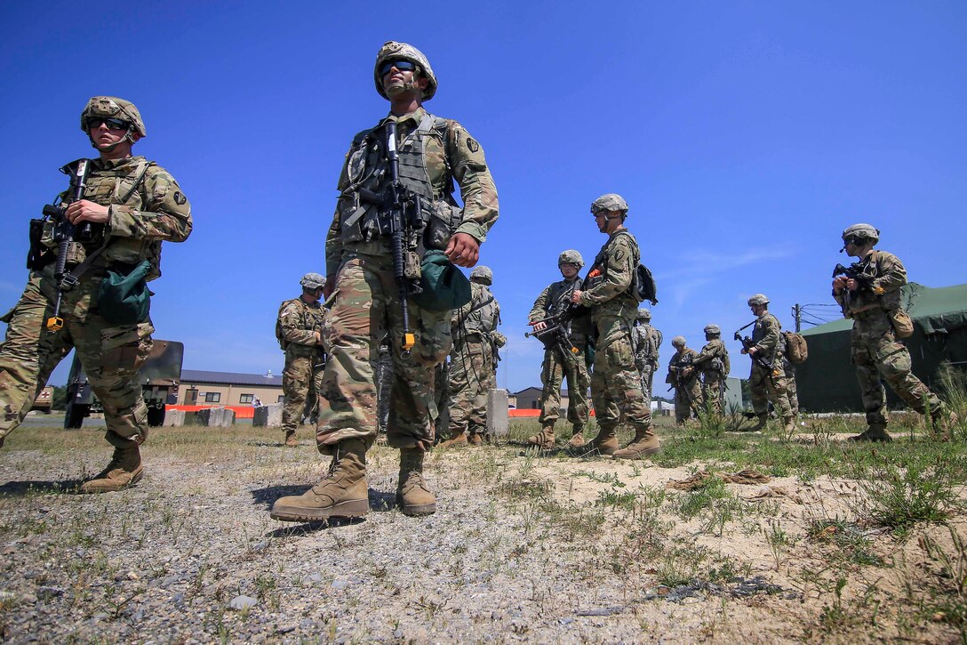 Soldiers walk toward an assembly pickup area before participating in air assault training.