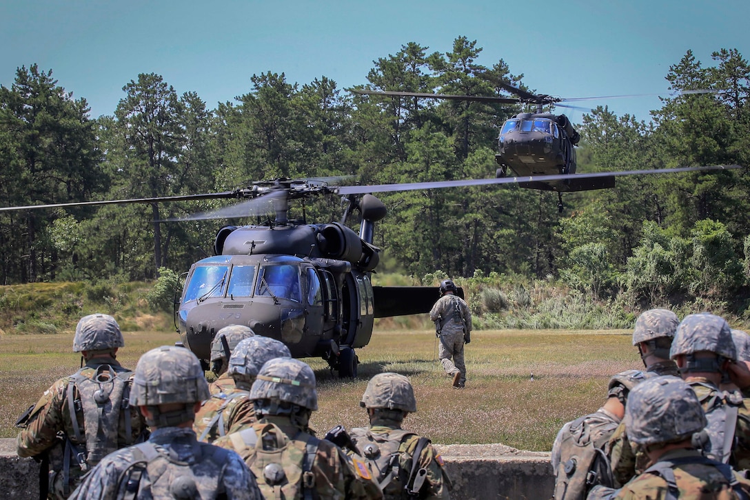 Soldiers prepare to board Army UH-60L Black Hawk helicopters.