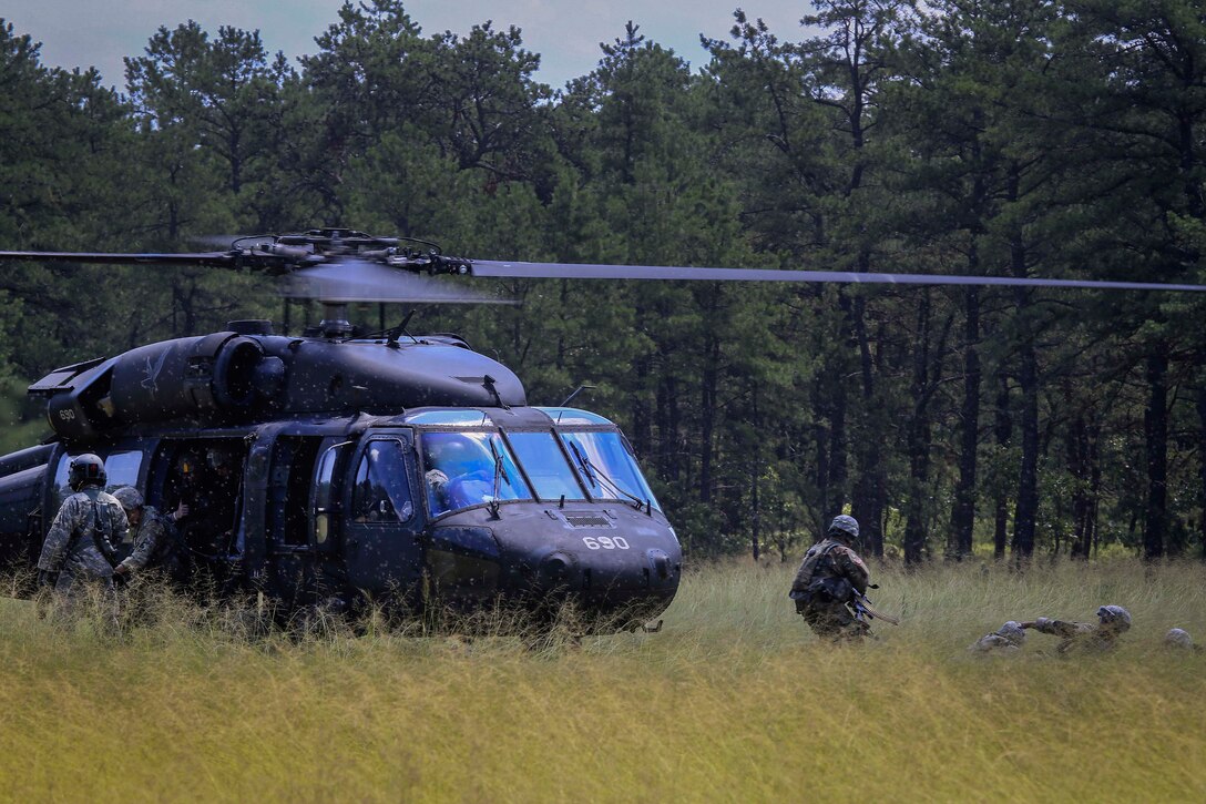 Soldiers disembark from a UH-60L Black Hawk helicopter during air assault training.