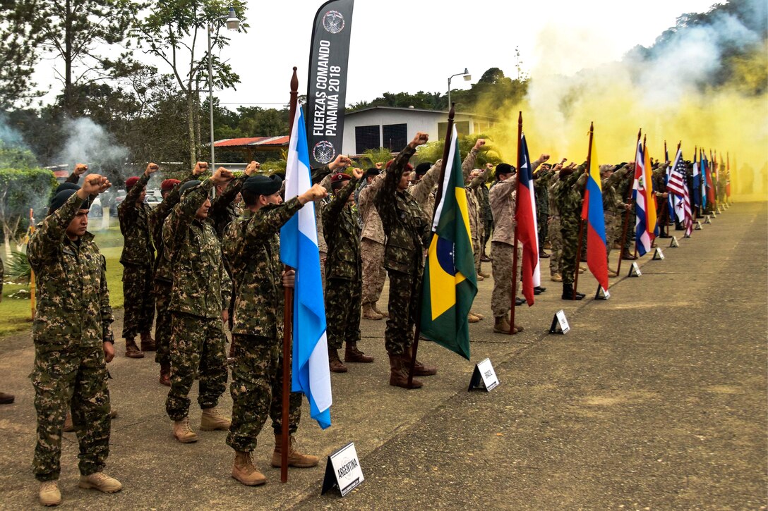 Special operation soldiers raise their fist and recite the Comando creed.