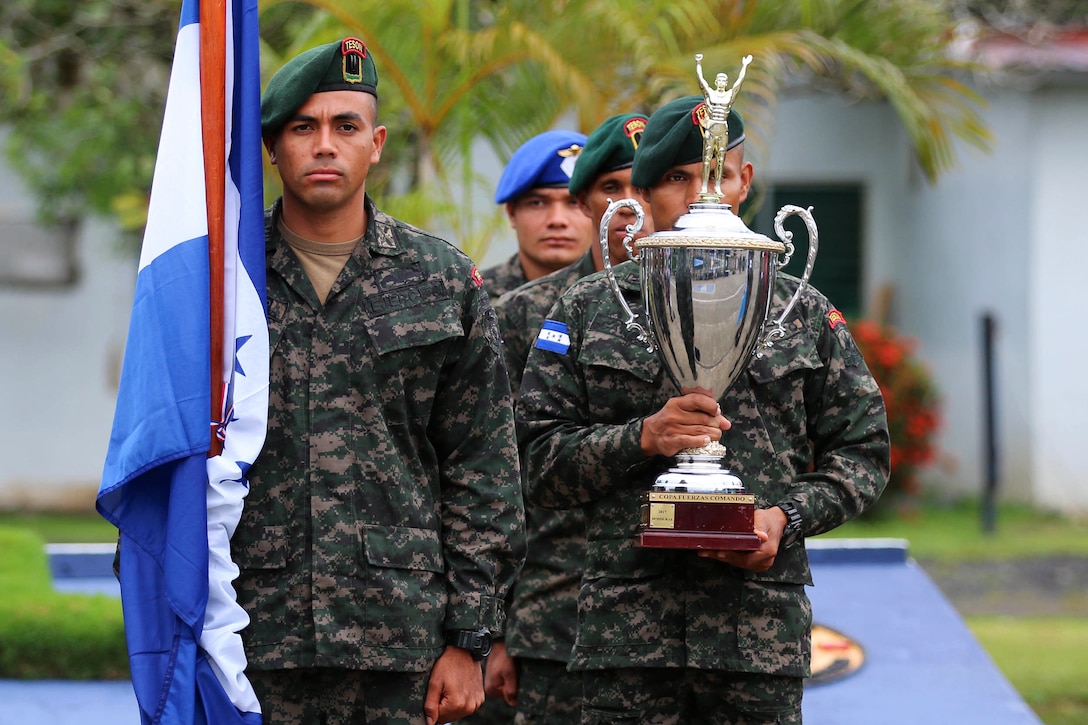 Panamanian commandos present the Fuerzas Comando 2018 trophy.