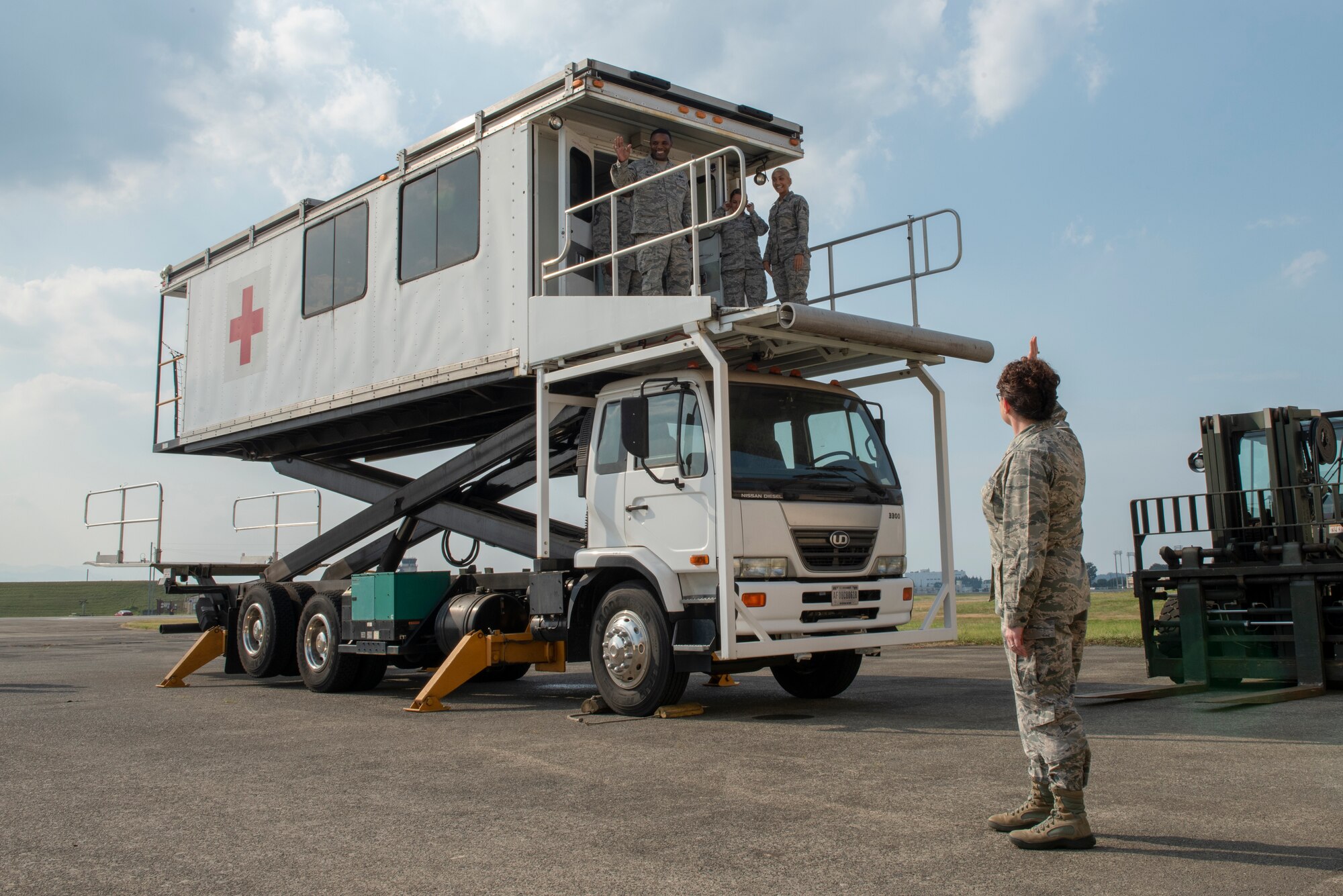 Col. Otis C. Jones, 374th Airlift Wing commander, waves from atop the En Route Patient Staging System during the 374th Medical Group immersion tour at Yokota Air Base, Japan, July 24, 2018.