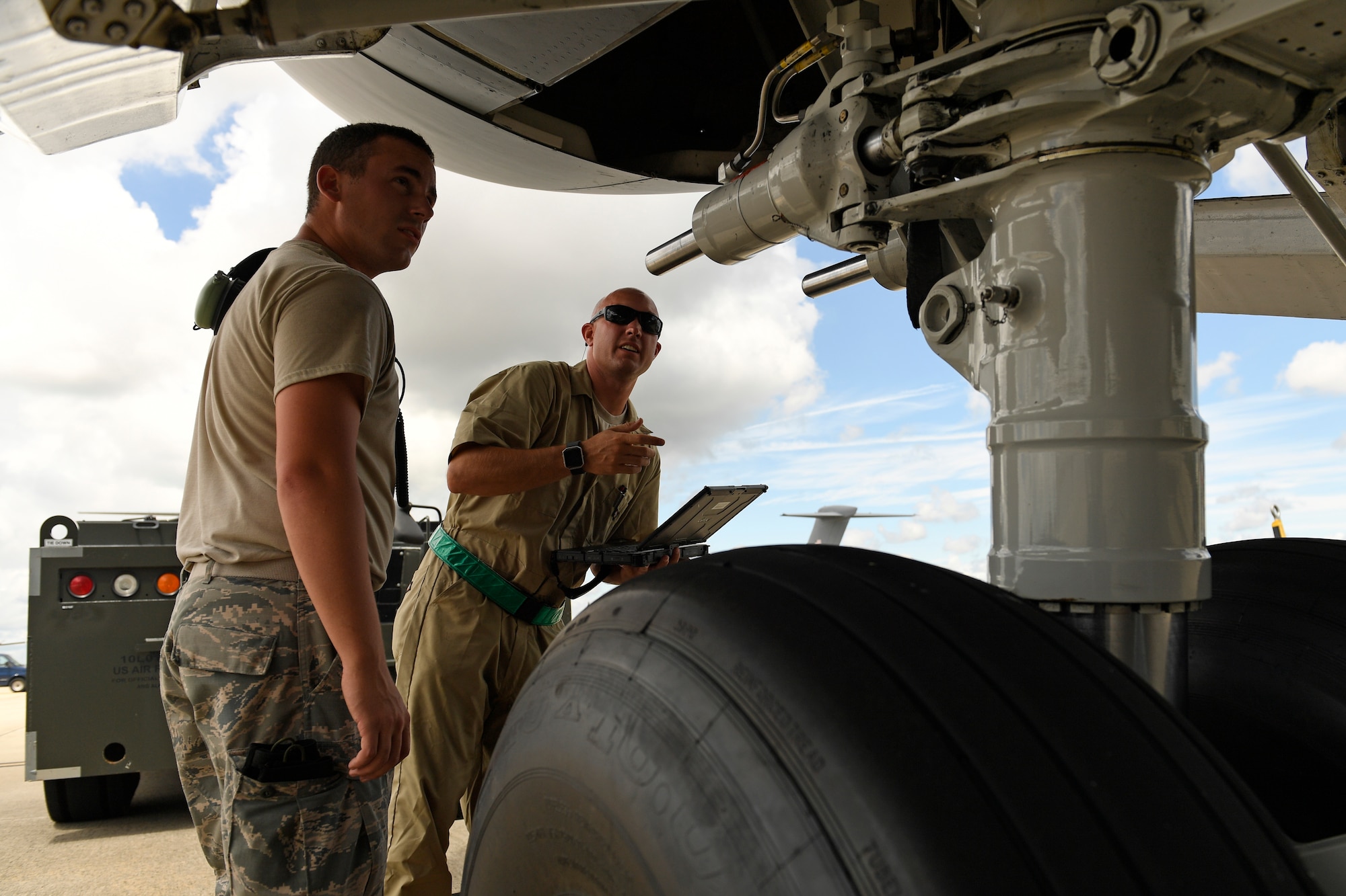U.S. Air Force Tech. Sgt. Jason Smigelski (right) trains Airman 1st Class Wayne Chandler (left), both from the 145th Aircraft Maintenance Squadron (AMXS), on the proper procedure for connecting a tow bar to a C-17 Globemaster III aircraft at the the North Carolina Air National Guard Base, Charlotte Douglas International Airport, July 24, 2018. Since the aircraft conversion in April, the 145th AMXS is working to train maintenance personnel with a goal of them being fully qualified.