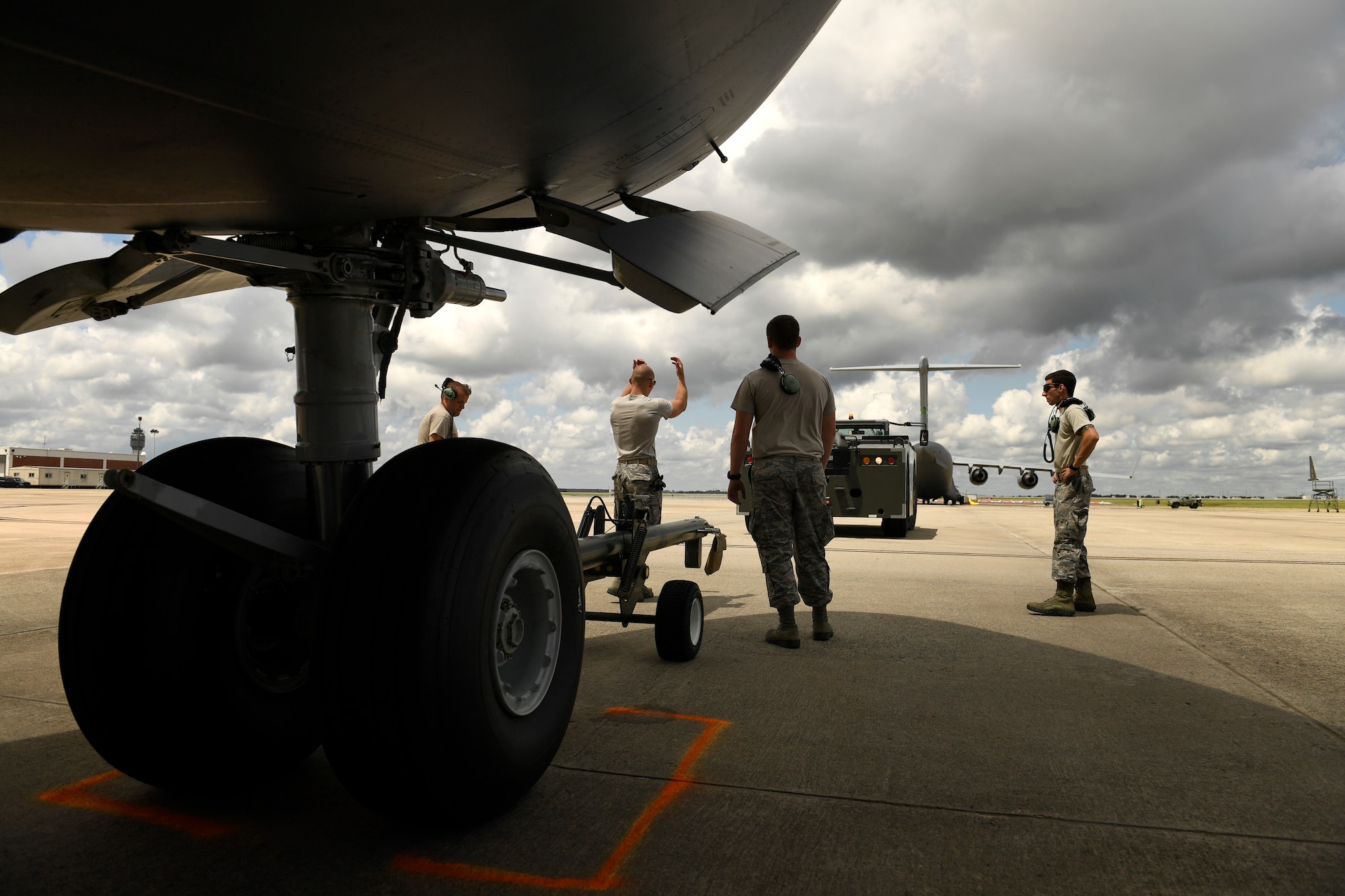 U.S. Air Force Staff Sgt. James Srackangast (center), 145th Aircraft Maintenance Squadron, gives hand and arm signals to direct a tow vehicle into position to tow a C-17 Globemaster III at the North Carolina Air National Guard Base, Charlotte Douglas International Airport, July 24, 2018. Maintenance personnel use hand and arm signals to direct each other and  ensure the safety of personnel and aircraft.