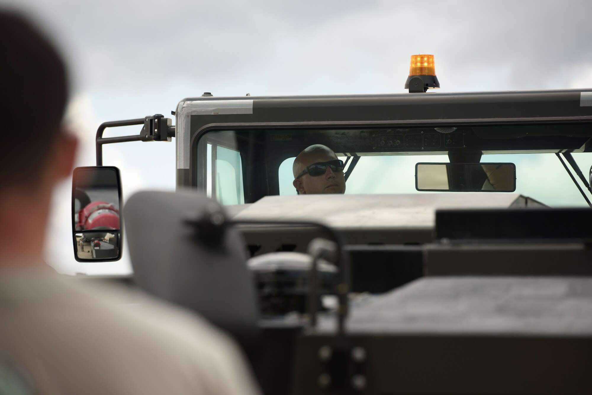 U.S. Air Force Tech. Sgt. Jason Smigelski (center), 145th Aircraft Maintenance Squadron, looks at his spotter for hand and arm signals to direct the tow vehicle into position to tow a C-17 Globemaster III at the North Carolina Air National Guard Base, Charlotte Douglas International Airport, July 24, 2018. Maintenance personnel use hand and arm signals to direct each other and  ensure the safety of personnel and aircraft.