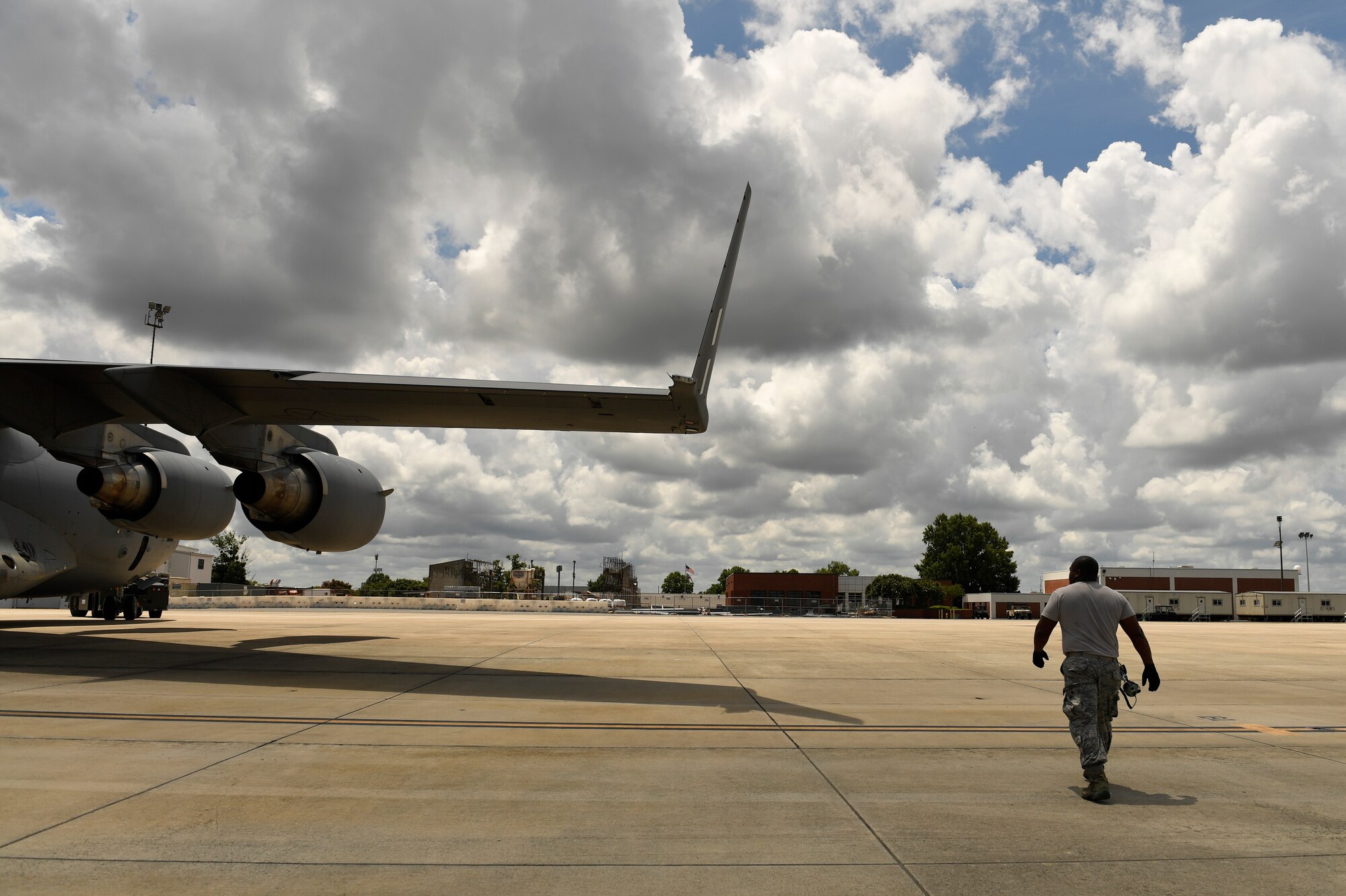 U.S. Air Force Senior Airman Nicklaus Moore, 145th Aircraft Maintenance Squadron, looks for any potential wing hazards while a C-17 Globemaster III is towed at the North Carolina Air National Guard Base, Charlotte Douglas International Airport, July 24, 2018. Moore is responsible to ensure the aircraft wing is clear throughout the towing process.