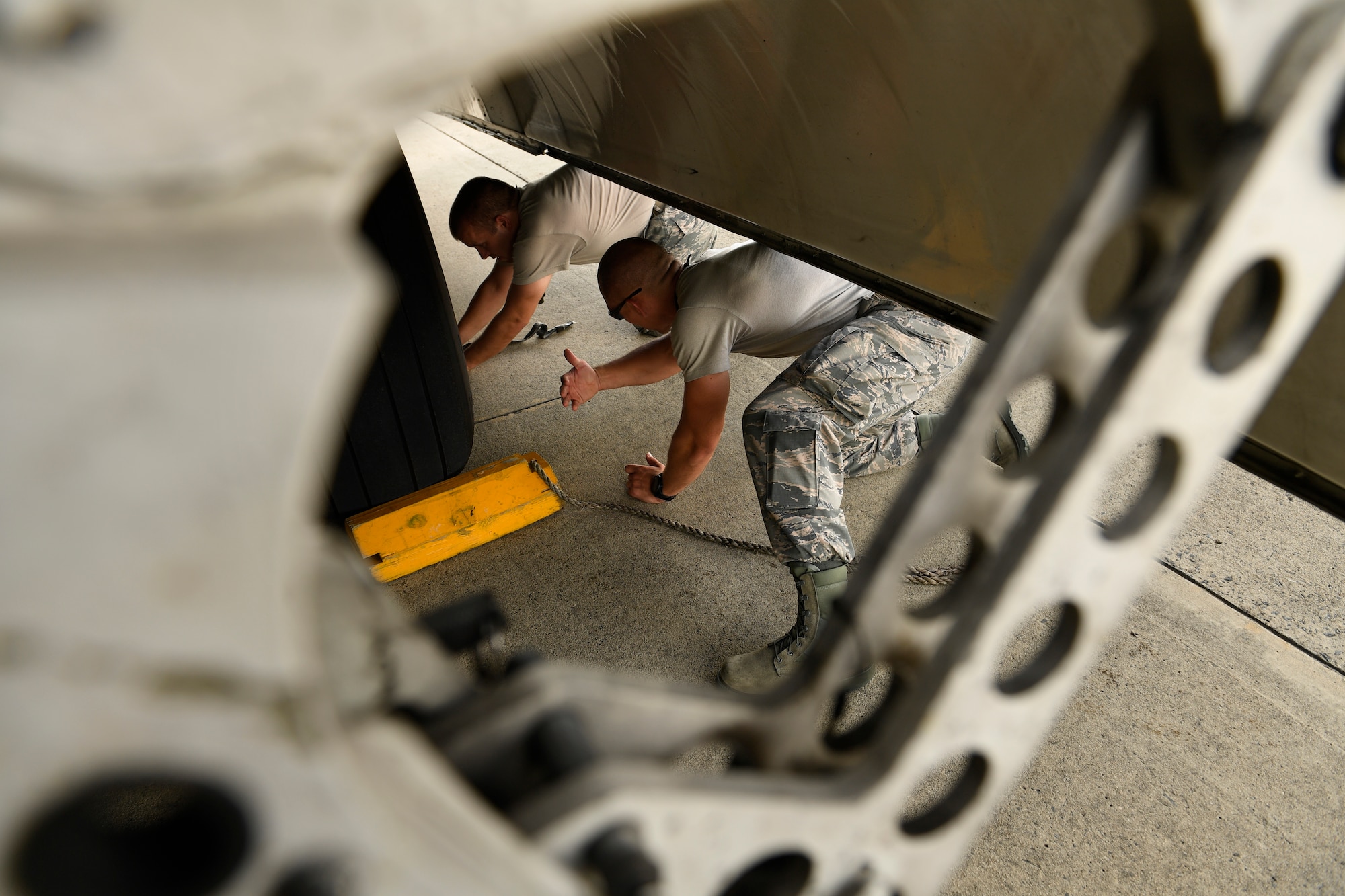 U.S. Air Force Tech. Sgt. Matthew Temple (left) and Staff Sgt. James Srackangast (right), 145th Aircraft Maintenance Squadron, place chalks under the wheels of a C-17 Globemaster III aircraft after towing it into position at the North Carolina Air National Guard Base, Charlotte Douglas International Airport, July 24, 2018. Chalks are a safety measure in place whenever the airframe is parked.