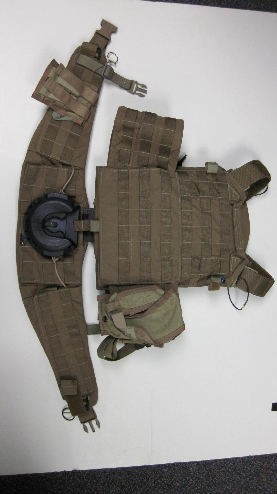 A military mounting system (MOLLE) and a hip belt with a Ruck Dock receiver is shown. The Ruck Dock receiver is part of a two piece system that allows a person carrying a MOLLE or other backpack  evenly distribute the weight and quickly couple or decouple the system. The technology was developed by the Air Force Research Laboratory 711th Human Performance Wing and licensed to Newcomer Arms LLC of New Jersey. (Photo courtesy of Newcomer Arms.)