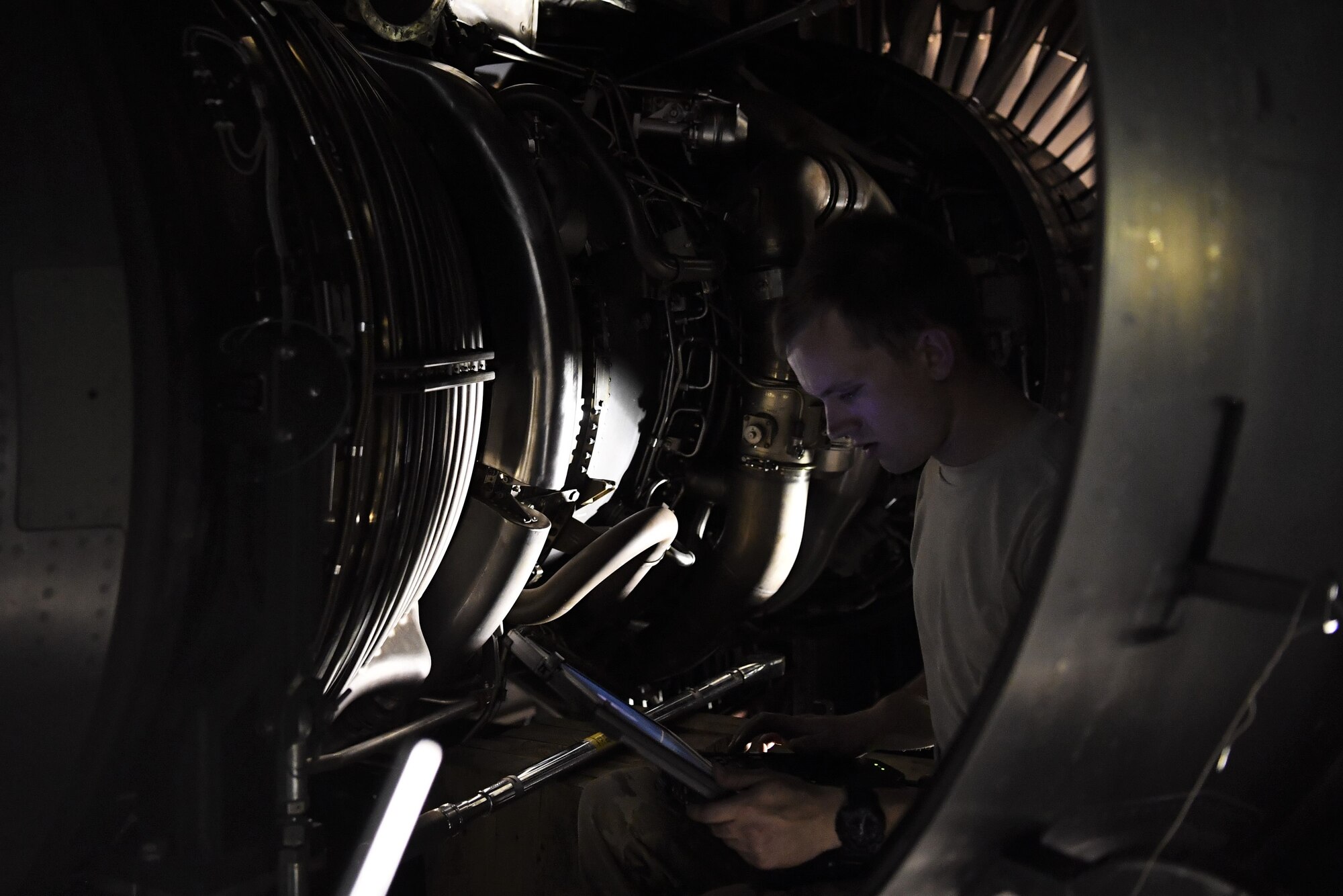 Staff Sgt. Sean Donnelly, 721st Air Mobility Operations Group airlift specialist mission maintenance craftsman, reviews engine schematics during an engine installation of a C-17 Globemaster III aircraft July 19, 2018, at an undisclosed location in Southwest Asia. Donnelly and his fellow 721st AMOG Airmen, who hail from Ramstein Air Base, Germany, delivered the engine and partnered with the 5th Expeditionary Mobility Squadron for the project. (U.S. Air Force photo by Staff Sgt. Christopher Stoltz)
