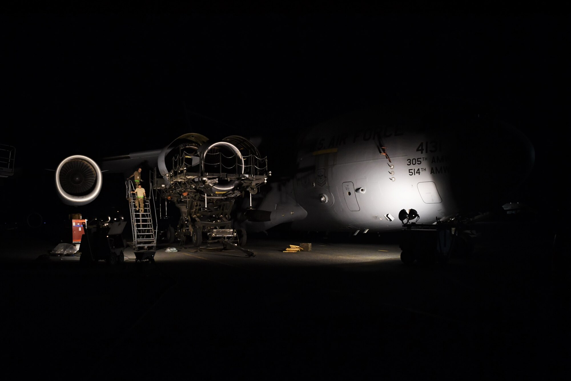 Members of the 5th Expeditionary Air Mobility Squadron descend a set of stairs during the installation of a C-17 Globemaster III aircraft July 19, 2018, at an undisclosed location in Southwest Asia. The 5th EAMS teamed up with the 721st Air Mobility Operations Group from Ramstein Air Base, Germany, to replace one of the four engines. (U.S. Air Force photo by Staff Sgt. Christopher Stoltz)