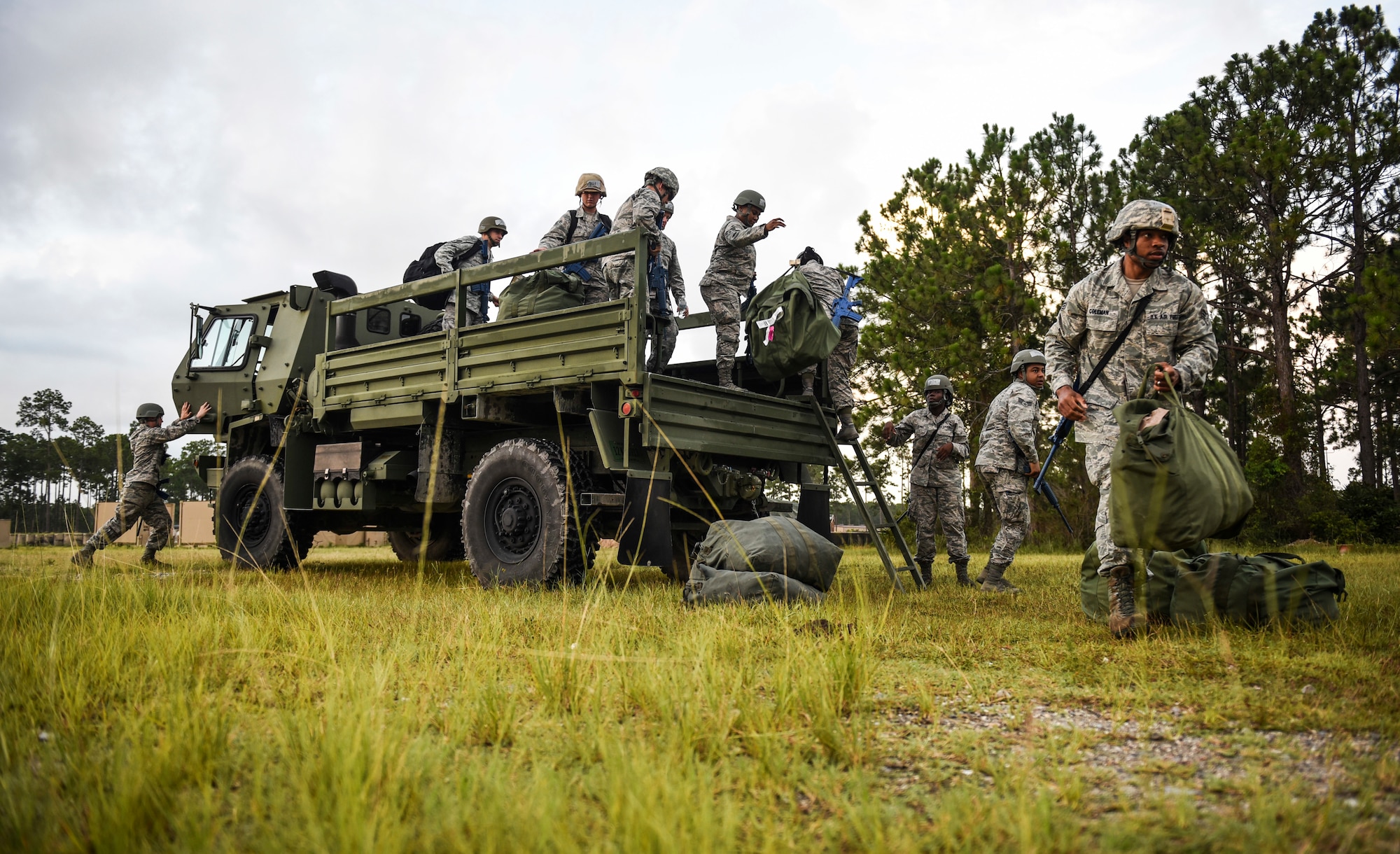 A group of U.S. Air Force force support squadron Airmen disembark a truck during an exercise at the Silver Flag training site on Tyndall Air Force Base, Florida, July 19, 2018.