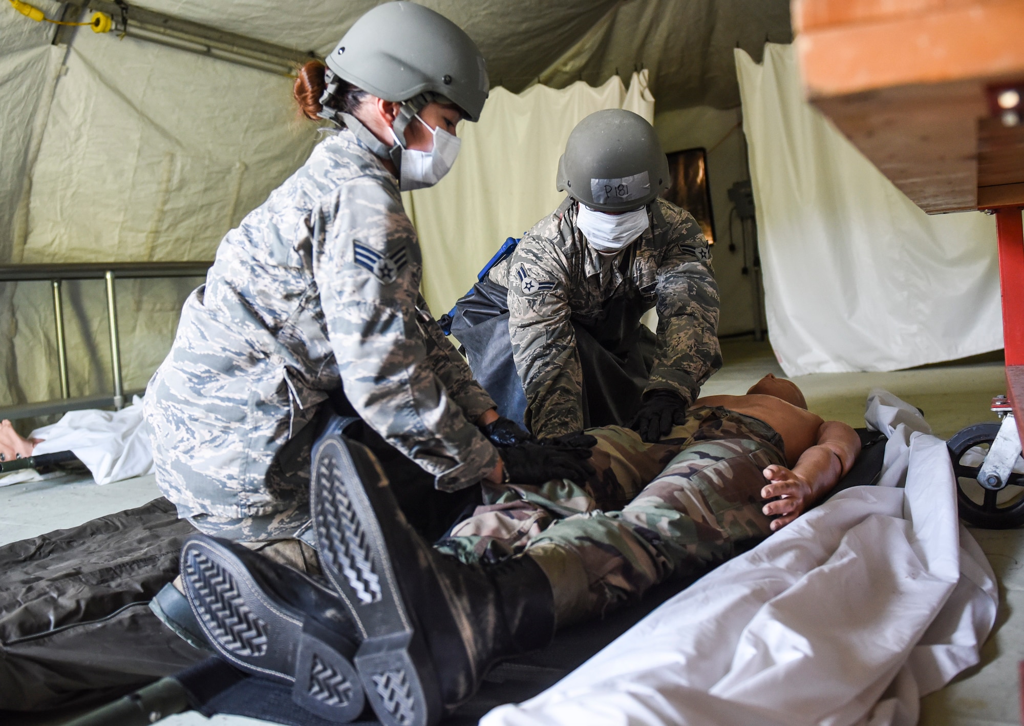 U.S. Air Force Senior Airman Michelle Torculas, left, and Airman 1st Class Jonathan Martinez, right, Silver Flag training site students from the 97th Force Support Squadron, Altus Air Force Base, Oklahoma, search a training dummy at Tyndall Air Force Base, Florida, July 19, 2018.