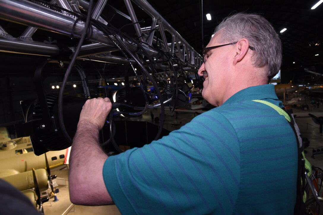 Museum Lighting Specialist Mike Behrens prepares theatrical lighting for the Memphis Belle exhibit in the WWII Gallery. (U.S. Air Force photo by Ken LaRock)