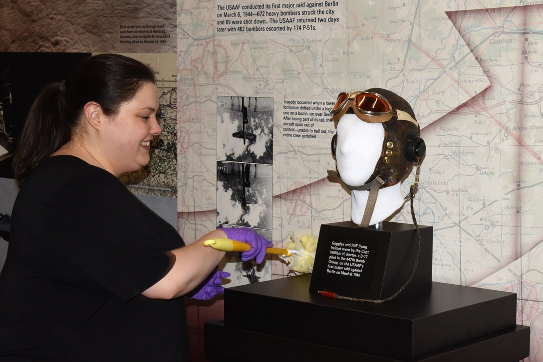 Museum Conservator Jennifer Myers prepares artifacts for display in the WWII Gallery. (U.S. Air Force photo by Ken LaRock)