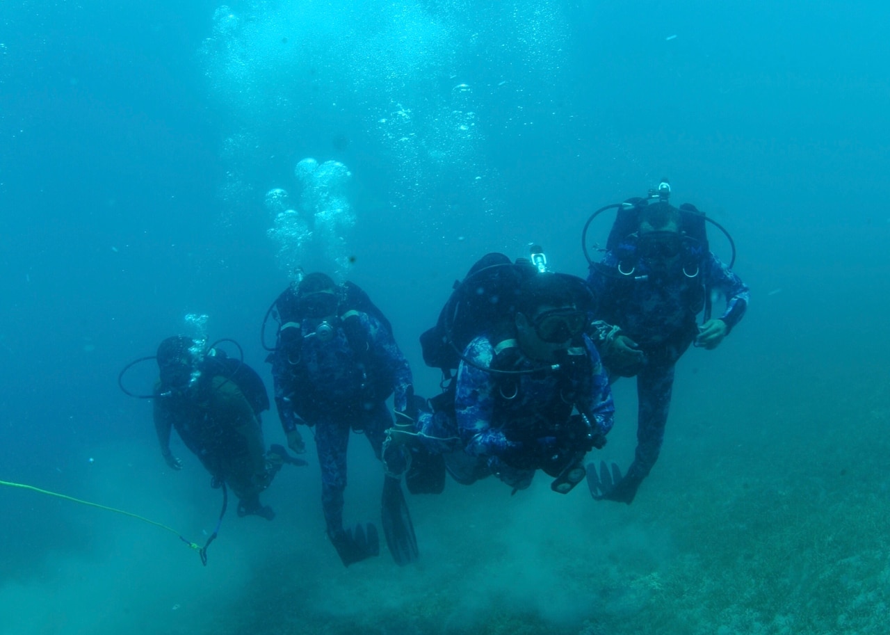An American sailor deployed to U.S. 5th Fleet’s Task Group 52.3, left, and Egyptian sailors conduct a familiarization dive during Exercise Eagle Response 18 at Red Sea Naval Base, Egypt, July 25, 2018. Eagle Response 18 is an explosive ordnance disposal and diving exercise conducted with the Egyptian navy to enhance interoperability and warfighting readiness, fortify military-to-military relationships and advance operational capabilities of all participating units. Navy photo