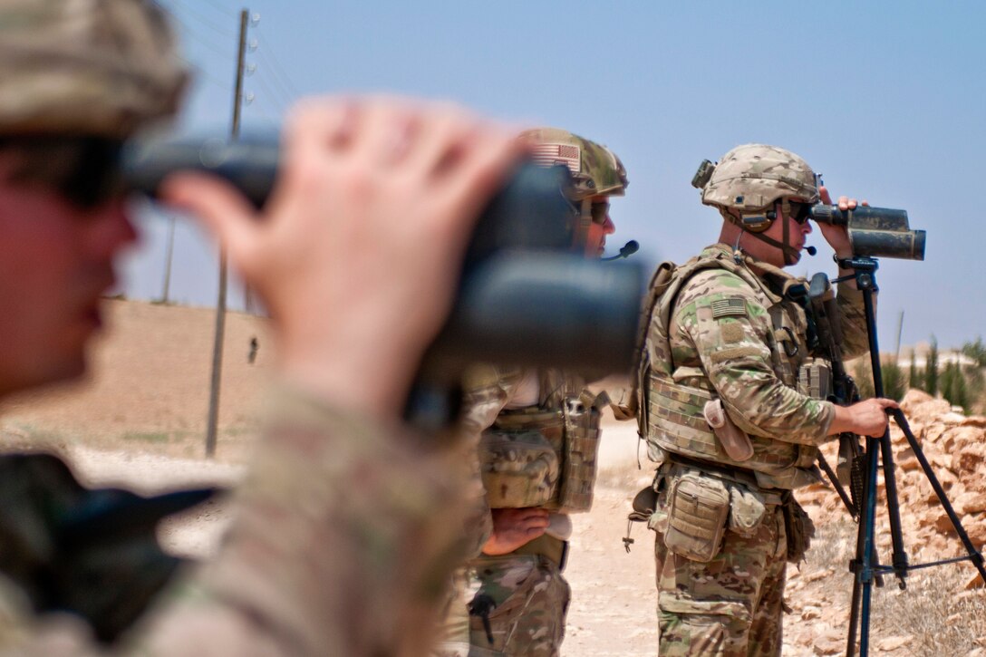 U.S. soldiers use spotting scopes to scan the area and make visual contact with Turkish troops.