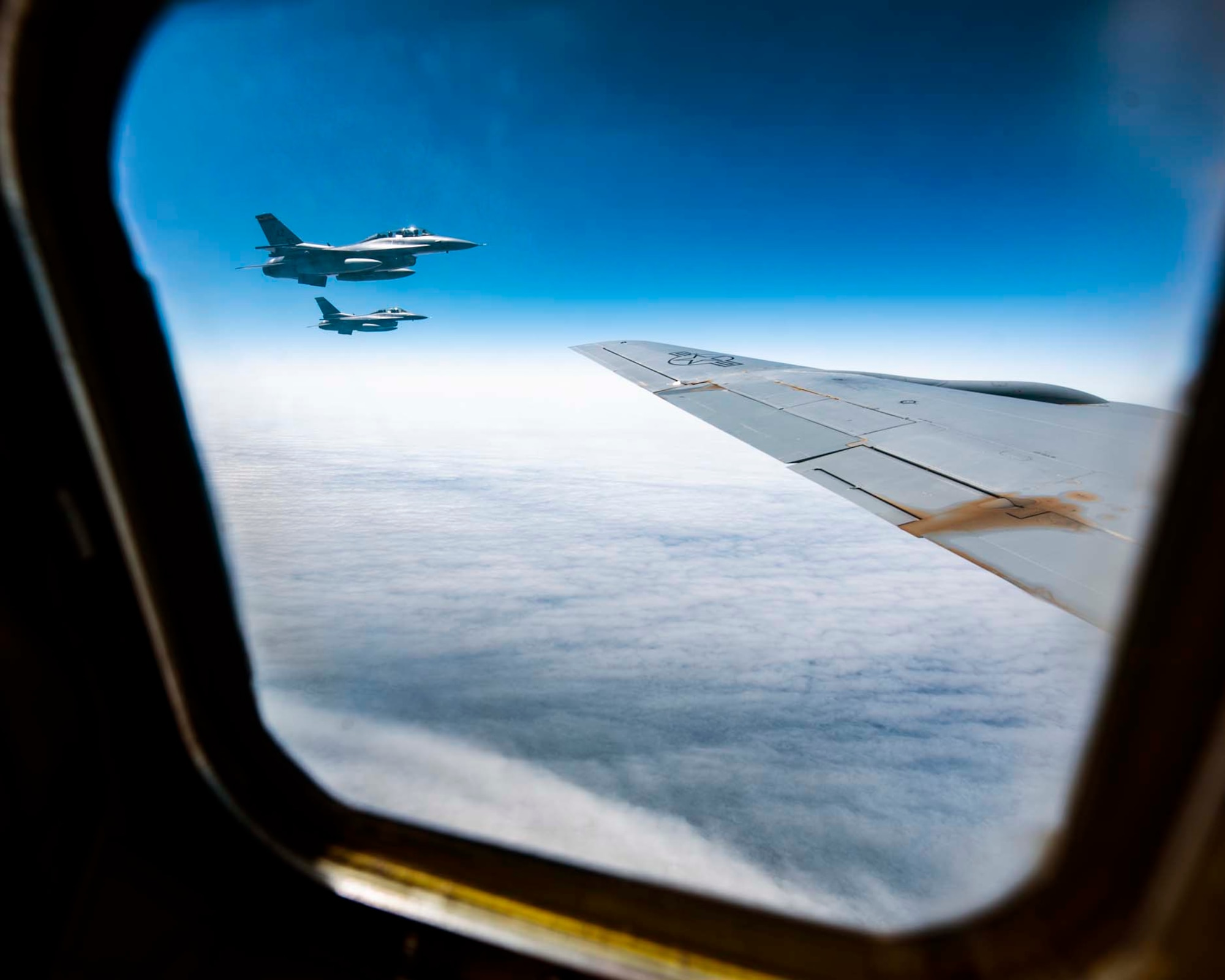 Two F-16D Fighting Flacons from the 162nd Fighter Wing in Tucson, Ariz. can be seen practicing air-intercept procedures from the window of a KC-135 Stratotanker from the 141st Air Refueling Wing over western Oregon during the Aerospace Control Alert CrossTell training exercise July 24, 2018. CrossTell is a three-day exercise involving multiple Air National Guard units, the Civil Air Patrol, and U.S. Coast Guard rotary-wing air intercept units to conduct training scenarios to replicate airborne intercepts designed to safely escort violators out of restricted airspace. (U.S. Air National Guard photo by Staff Sgt. Rose M. Lust)