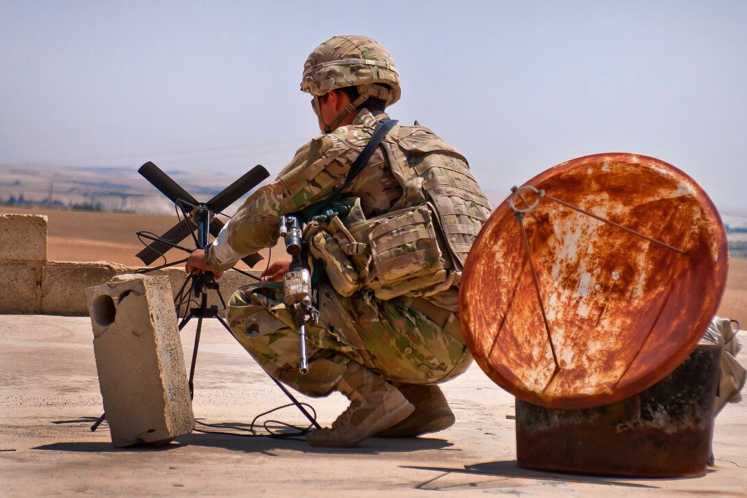 A soldier sets up an antenna to transmit a situational report to his higher headquarters.