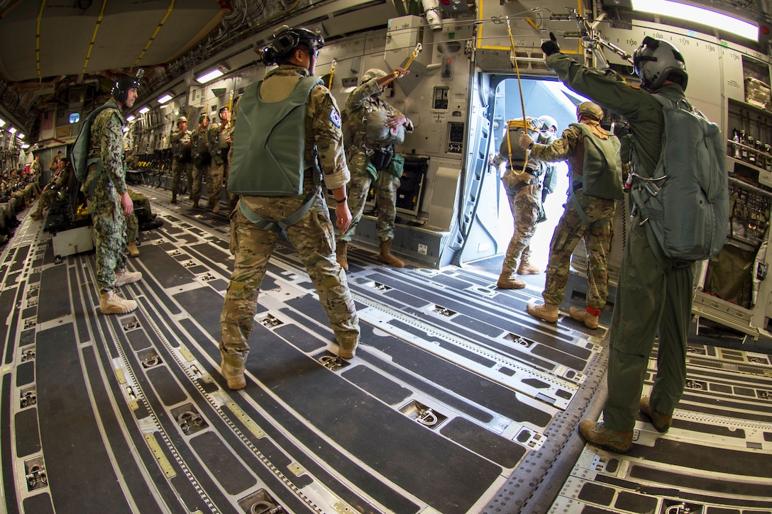 A Republic of Korea Navy sailors observes a chock jumpmaster looking for the drop zone during static line airborne training.