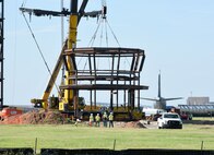 The enormity of the cab compared to the people on the ground is apparent as it is prepared to be hoisted and positioned in place by contractors July 13. The new tower is expected to be complete by March 2019.