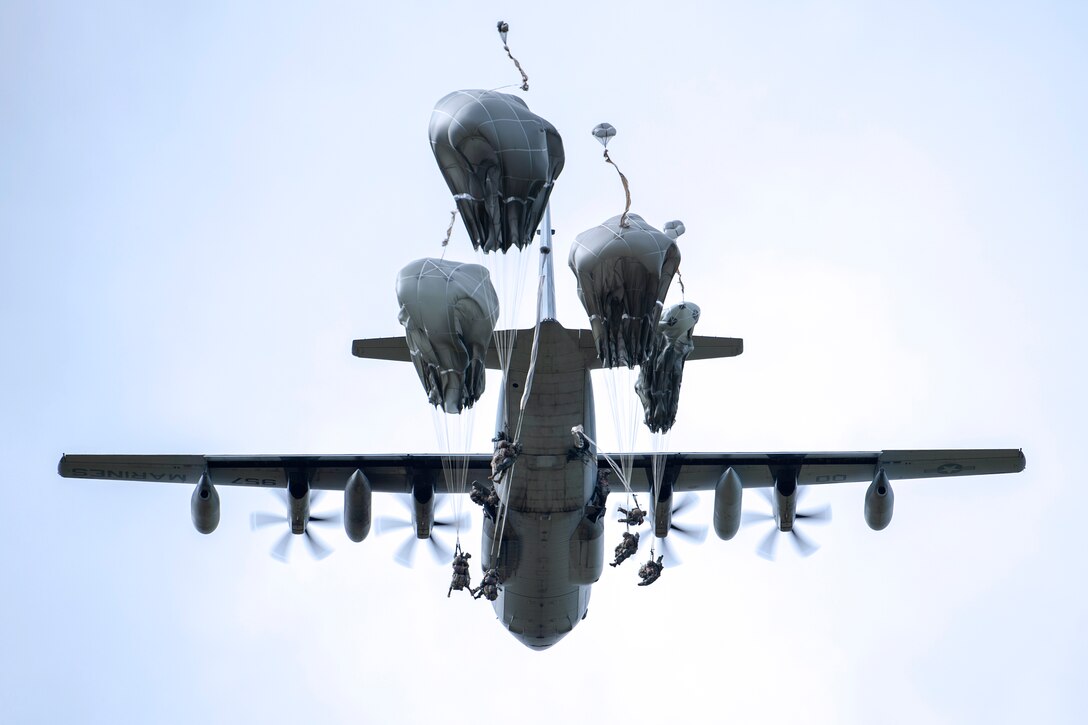 Soldiers exit a C-130 Hercules aircraft during an airborne operation.
