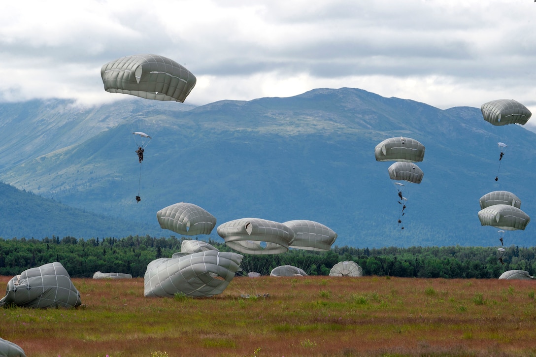 Soldiers perform parachute landing fall during an airborne operation.