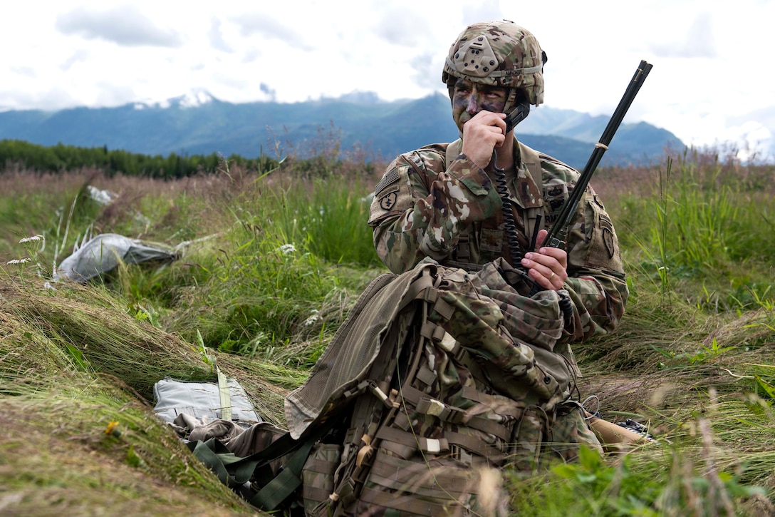 A soldier uses a field radio to communicate with his headquarters leadership team.