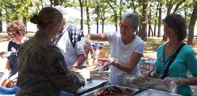 Volunteers from the Dallas/Fort Worth United Service Organization (USO), serve lunch to Senior Master Sgt. Tia Kancilia, 301st Fighter Wing staff resource advisor, July 15, 2018. Airmen from multiple units in the wing received a barbecue lunch provided by the USO during the unit training assembly. The goal of the lunch was to increase morale among airmen. (U.S. Air Force photo by Tech. Sgt. Charles Taylor)