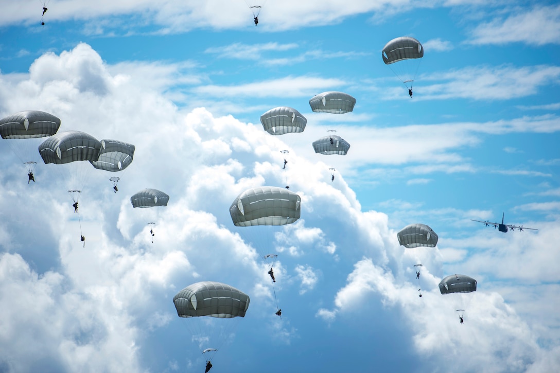 Soldiers fill the sky with full chutes during an airborne operation.