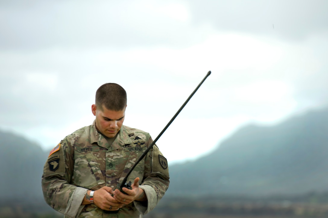 A soldier talks to his headquarters leadership team and provides them with the wind speed readings.